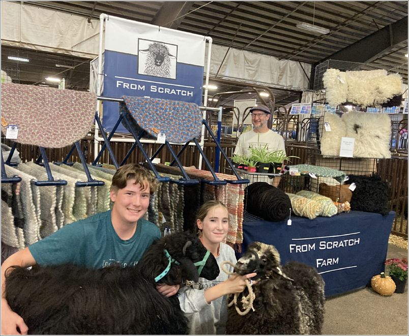 Members of From Scratch Farm Lebanon, Oregon, show their sheep in their vendor booth. Next photo shows a portion of their business card. Photo: Evelyn Taylor.